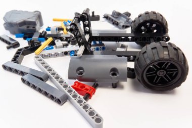 Yapıcının plastik parçaları, hareket edebilen modelleri beyaz arka planda birleştirmek için elementleri ve tekerlekleri bağlayan, yüzen odaklı