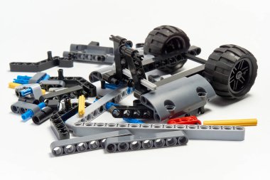 Yapıcının plastik parçaları, hareket edebilen modelleri beyaz arka planda birleştirmek için elementleri ve tekerlekleri bağlayan, yüzen odaklı