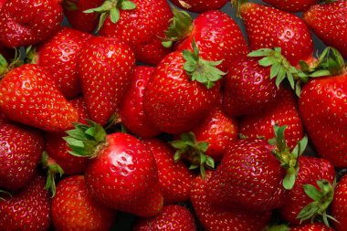 Siyah arka planda olgun kırmızı çilekler, yakın çekim üst manzara.