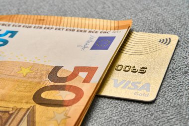 Altın renkli banka kartı ve nakit.