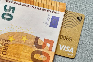 Altın renkli banka kartı ve nakit.