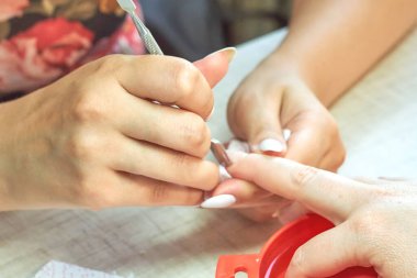Efendi kıza manikür yaptırıyor. Yakın plan..