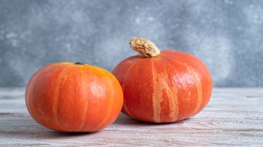 Arka plan olarak güzel bir çift balkabağı. Duvar kâğıdı. Sağlıklı turuncu sebze. Küçük güzel balkabakları