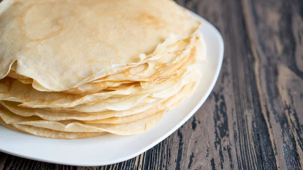 Vue latérale des crêpes cuites au four sont empilés les uns sur les autres. Crêpes simples traditionnelles pour le petit déjeuner des enfants — Photo