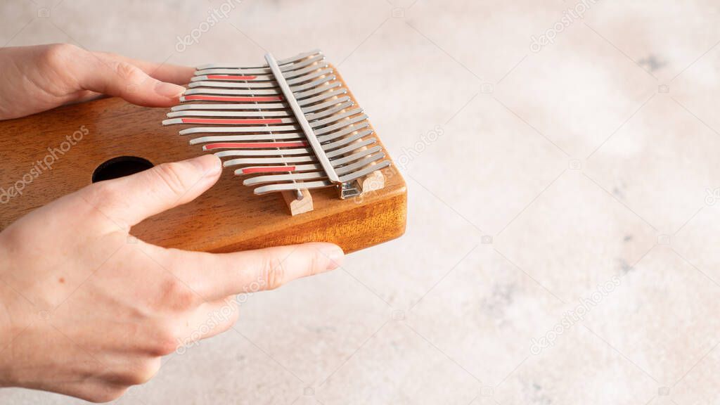 Hands playing the African instrument Kalimba. Mbira is musical instrument. Side view