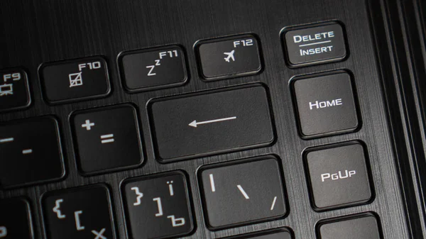 Chiuda il pulsante backspace di un computer portatile. Tastiera nera per laptop. Moderna freccia grande come pulsante backspace sulla tastiera — Foto Stock