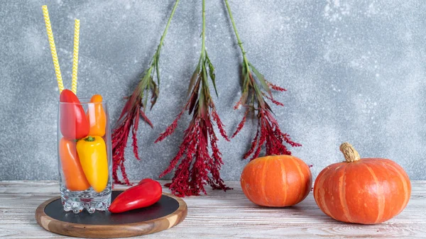 白い木製のテーブルの上に様々な秋の季節の有機野菜。赤いドライフラワー。秋の装飾コンセプト — ストック写真