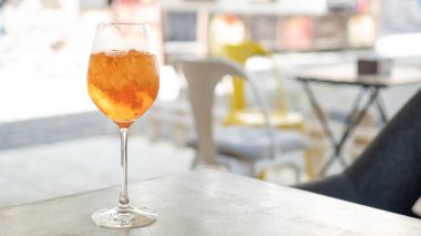 Kafede kokteyl aperol spreyi. Aperol Spritz Kokteyli. Parlak arkaplanda elinde alkollü içecek.