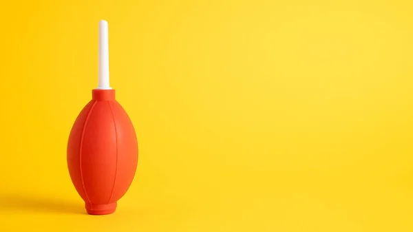 Isolated red rubber air blower for cleaning dust from the camera and lens on yellow background — Stock Photo, Image
