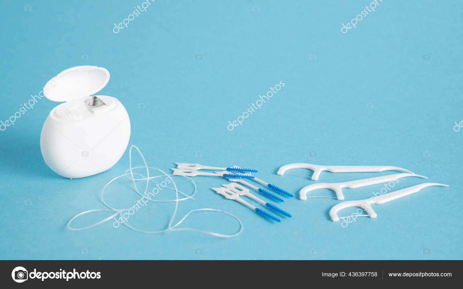 Home dental care kit. Different tools for dental care on blue background. Floss picks floss