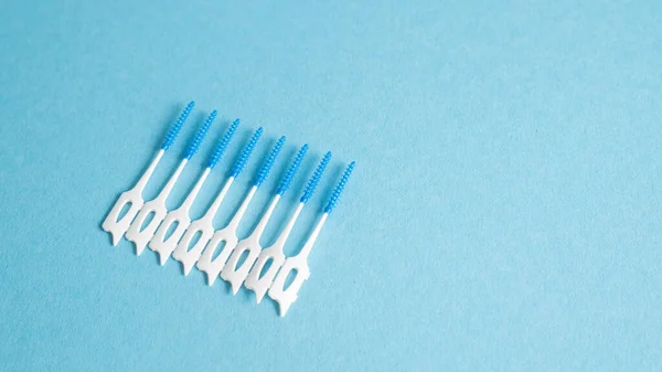 Evde diş temizleme seti. Diş hijyeni için küçük bir arsızlık. Diş bakımı. Diş temizleme aleti. Mavi üzerine interdental fırça