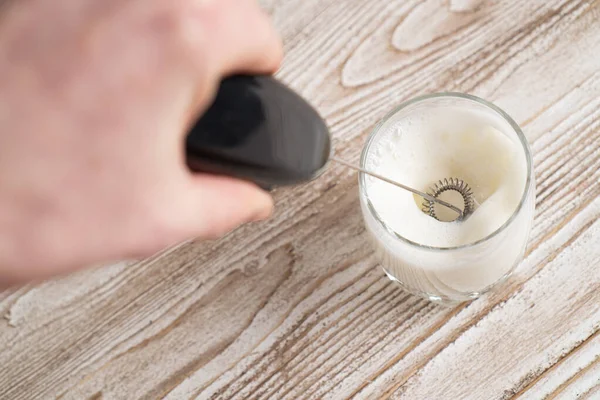 Milk frother making milk foam. Top view. Black mixer whipping milk. Milk frother device — Stock Photo, Image