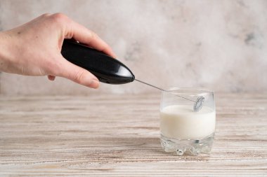 Süt köpüğüyle sütü bardağa karıştırıyorum. Köpüklü süt yapıyorum. Süt el bilgisayarı karıştırıcı.