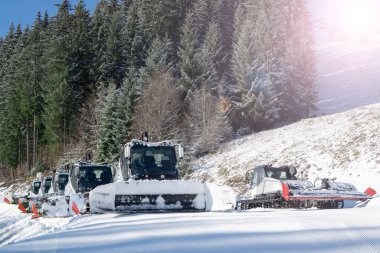 Yokuşta kar kedileri. Kar temizleme makineli modern kar temizleme pisti kayak pistini hazırlıyor