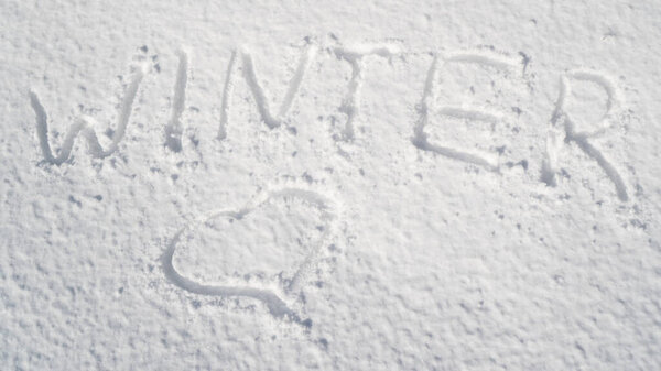Snowy background with inscription winter and heart shape. Snowy background as the concept of winter lovers. Valentines Day