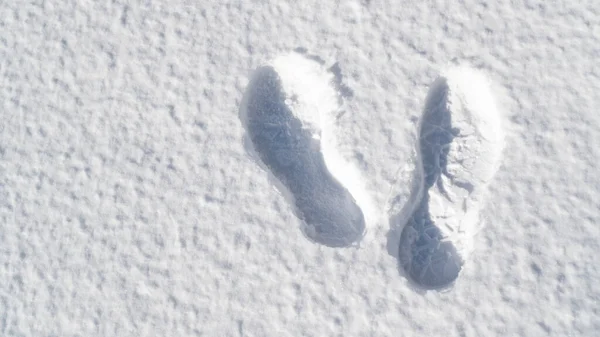 Следы правой стороны в свежем снегу в солнечный день. Очистить снежную поверхность отпечатками ног. — стоковое фото