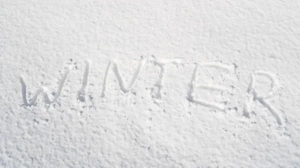 Надпись ЗИМА на свежем снегу в солнечный день. Текстура снега. Зимнее сообщение написано от руки на свежем снегу — стоковое фото