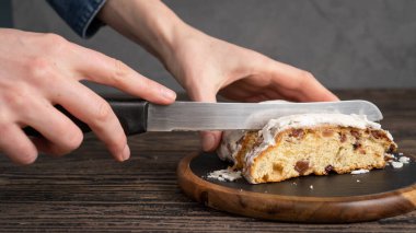 Aşçının elleri mutfakta bıçakla Stollen keki dilimliyor. Pudra şekeriyle kaplanmış çalınmış