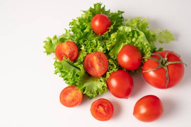 Beyaz arka planda marul ve domates malzemelerinin üst görüntüsü. Mükemmel yeşil ve kırmızı sebzeler.