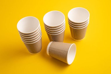 Kağıt kahve fincanları. Sarı arka planda çay için kağıt bardaklar. Sıfır atık. Gri renkli kahve kağıdı bardakları