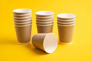 Kağıt kahve fincanları. Sarı arka planda çay için kağıt bardaklar. Sıfır atık. Gri renkli kahve kağıdı bardakları