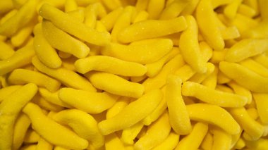 Arka plan olarak jöleli muzlar. Muzlu taze meyveli jöle. Sarı, tatlı bir arka plan. Muz aromalı sakız, sakız.