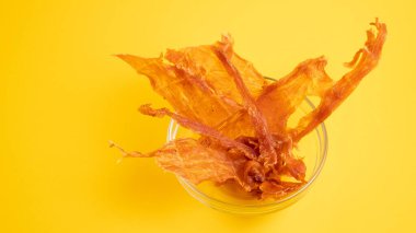 Şarap ya da bira için kurutulmuş et. Sarı arka planda cam kasede et aperatifi.