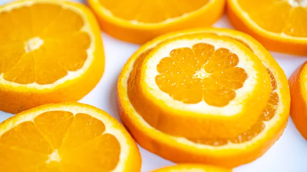 Pomarańcza w plasterkach o doskonałej strukturze i skórze. Soczyste pomarańczowo-białe tło z pomarańczami. Dojrzała pomarańcza hiszpańska — Zdjęcie stockowe