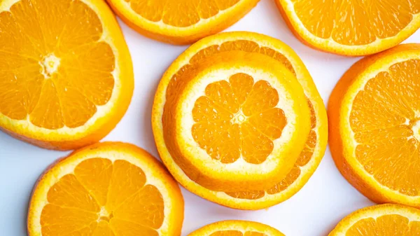 Pequenas e grandes fatias de laranja. Laranja cortada sobre fundo branco. Mais fraco, menor e diferente — Fotografia de Stock