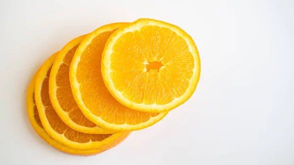 Círculos laranja empilham em um fundo branco. Vida saudável. Espaço para cópia. Abeto de fatias de laranja — Fotografia de Stock