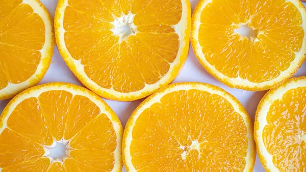 Grandes fatias de laranja fechar. Círculos laranja em um fundo branco. Fibra perfeitamente construída. Vida saudável — Fotografia de Stock