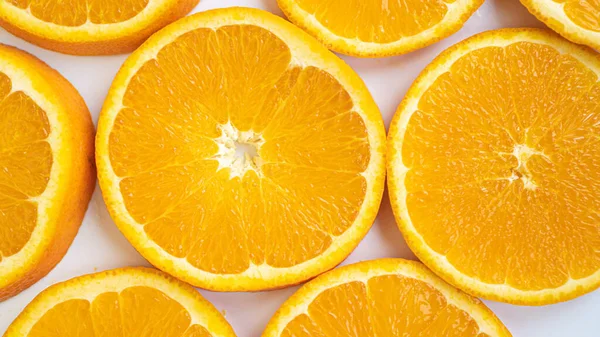 Grandes fatias de laranja fechar. Círculos laranja em um fundo branco. Fibra perfeitamente construída. Vida saudável — Fotografia de Stock