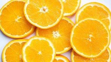 Olgun Türk portakalı. Sulu büyük portakal çemberleri. Beyaz arka planda dilimlenmiş turuncu. Düz yatış, üst görünüm