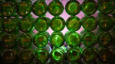 Arkadaki yeşil şişelerden oluşan bir duvar. Cam arka plan, cam doku. Yeşil camın dibindeki doku.
