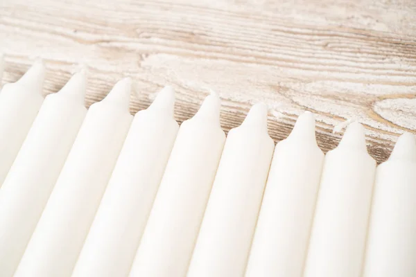 Conjunto de velas simples. Candelabros blancos. Velas largas de cera sobre mesa de madera. Nuevo conjunto de velas largas — Foto de Stock
