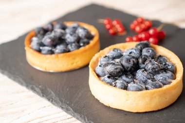 Siyah tabakta yabanmersinli tart. Böğürtlenli ev yapımı tartlar. Yabanmersinli tart tarifi. Böğürtlenli.