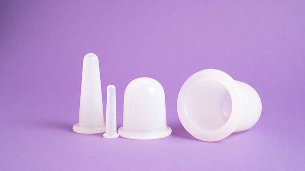 Massage cupping set on purple background. Massage vacuum jars. Silicone cups for vacuum therapy. Anti cellulite cups