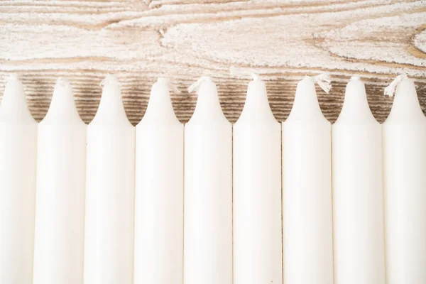 Nuevo conjunto de velas blancas sobre mesa de madera. Velas en fila. Velas largas de cera. Conjunto de velas tradicionales. — Foto de Stock