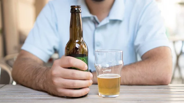 Single man with a beer bottle. Man holding a beer. Man holding lagger beer — Stock Photo, Image