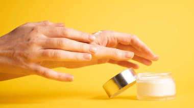 Sarı üzerine el kremi. Kadın ellerine el nemlendirici kremi sürüyorum.