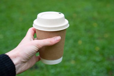 Yağmurlu kahve. Biyo-çözünebilir bardak elinde. Tek kullanımlık kupa. Sonbahar kahvesi hazır. Sokakta kağıt bardakta kahve.