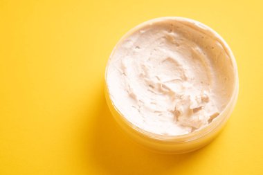 Sarı arka planda çamur maskesi. Pembe yüz maskesi kremi. Nemlendirici reklamlar. Pembe kil maskeli reklam filmi