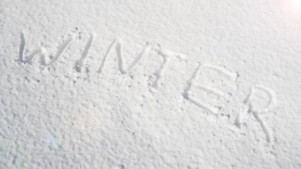 Надпись зима на белом снегу. Слово зима написано на снегу. Зимнее сообщение написано от руки на свежем снегу — стоковое фото