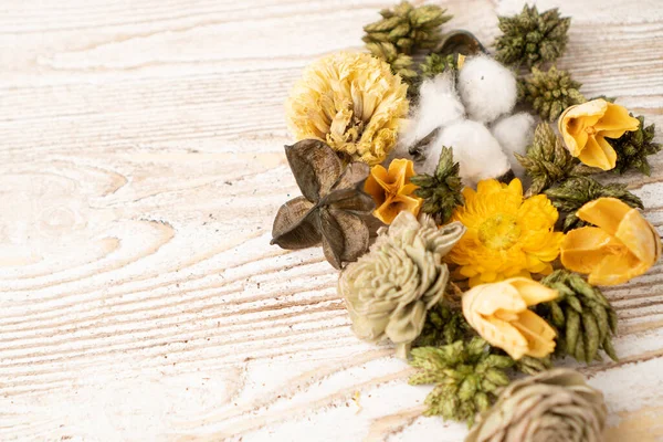 Flores y hojas secas con aroma verde sobre una mesa de madera. Flores de popurrí amarillo o pétalos secos sobre mesa de madera — Foto de Stock