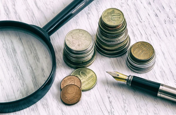 Pengar; ett öre; mynt; Verksamhet. förstoringsglas; en penna; budget — Stockfoto