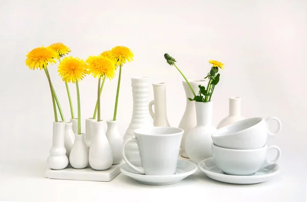 Одуванчики, белая ваза — стоковое фото