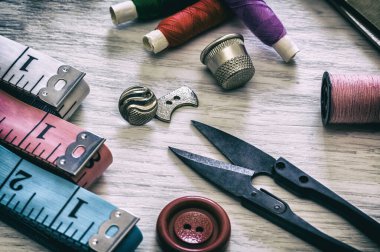 Dikiş işi için çeşitli aksesuarlar. Kumaş ve iplik makaraları, makas ve yüksük için dikiş malzemeleri. Retro tonlama