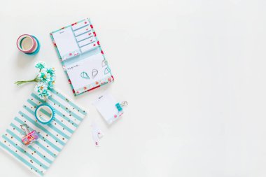 Open notebook, notebook with colored paper clips, clip, tape on a white background. Stationery and details for work. View from above. Place for text