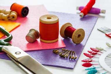 Yaratıcı bir imaj. Dikiş için bir takım aksesuarlar, iplik makaraları, kumaşlar, makas ve yüksük kadar yakın çekim.