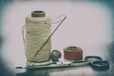 Beyaz arka planda el yapımı dikiş aksesuarları, terzi bandı, iplik makarası, makas, yüksük. Dikiş seti. Retro tarzı. Metnin için yer.